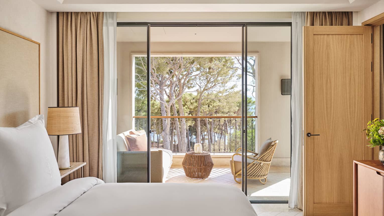 Contemporary suite bedroom with king bed and walk-out, pine-view balcony at Four Seasons Resort Mallorca