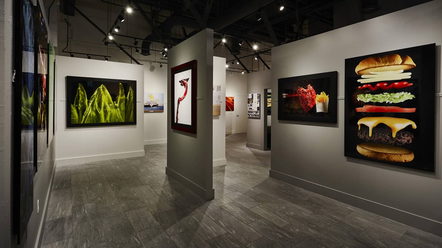 Images of food including a deconstructed burger and fries with ketchup fill the Modernist Cuisine Gallery in Seattle