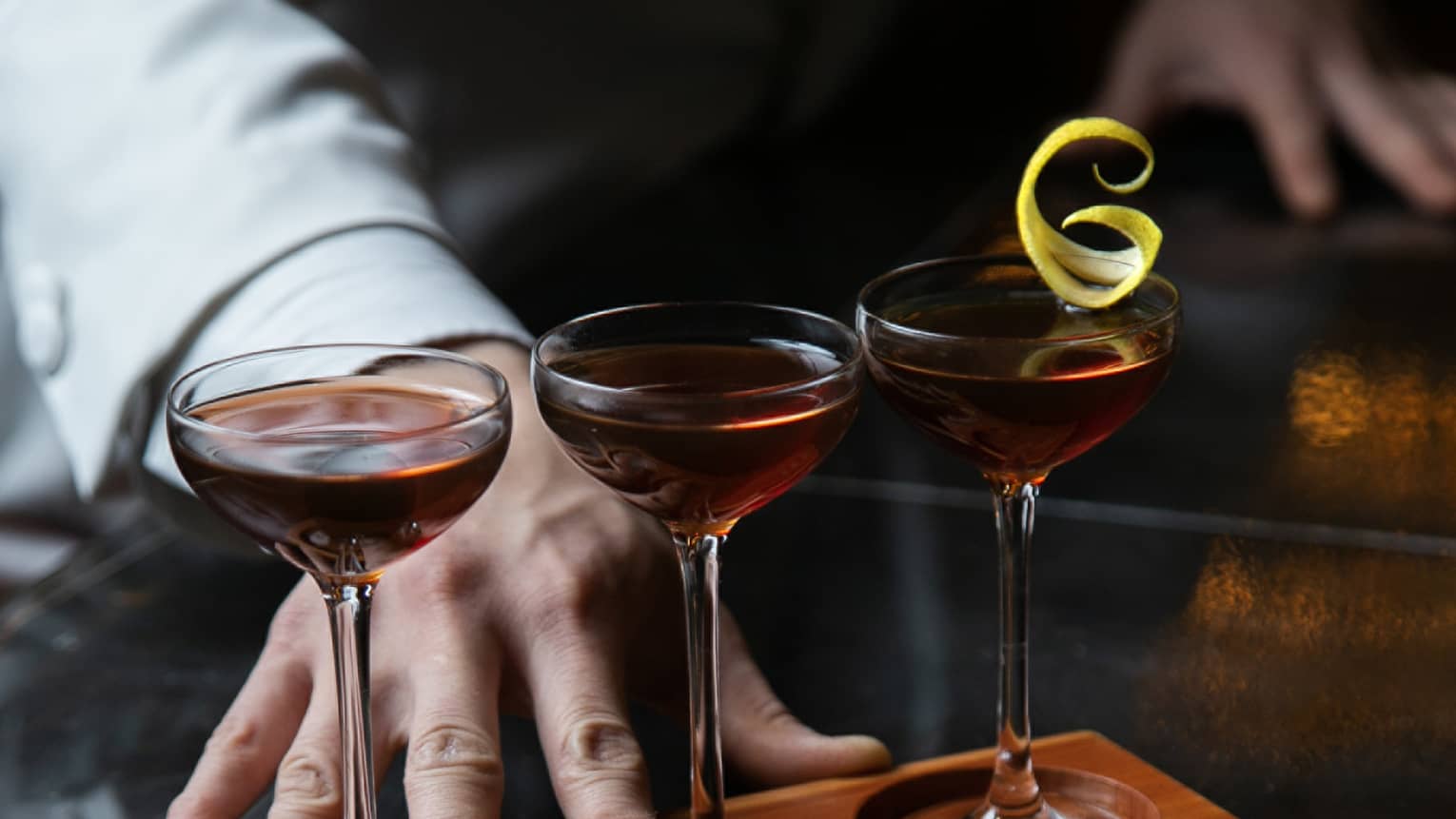 Row of three cocktails ? Classic Manhattan, De La Louisiane and Vieux Carr� ? in wooden stand