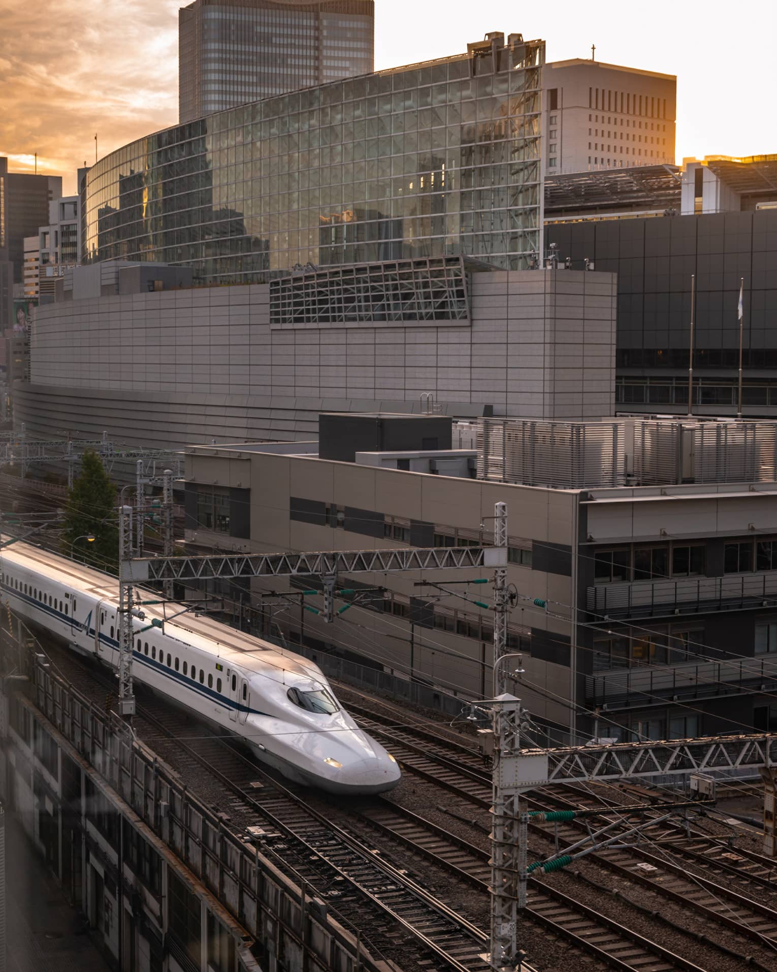 Shinkansen bullet train arrives at the station at sunset