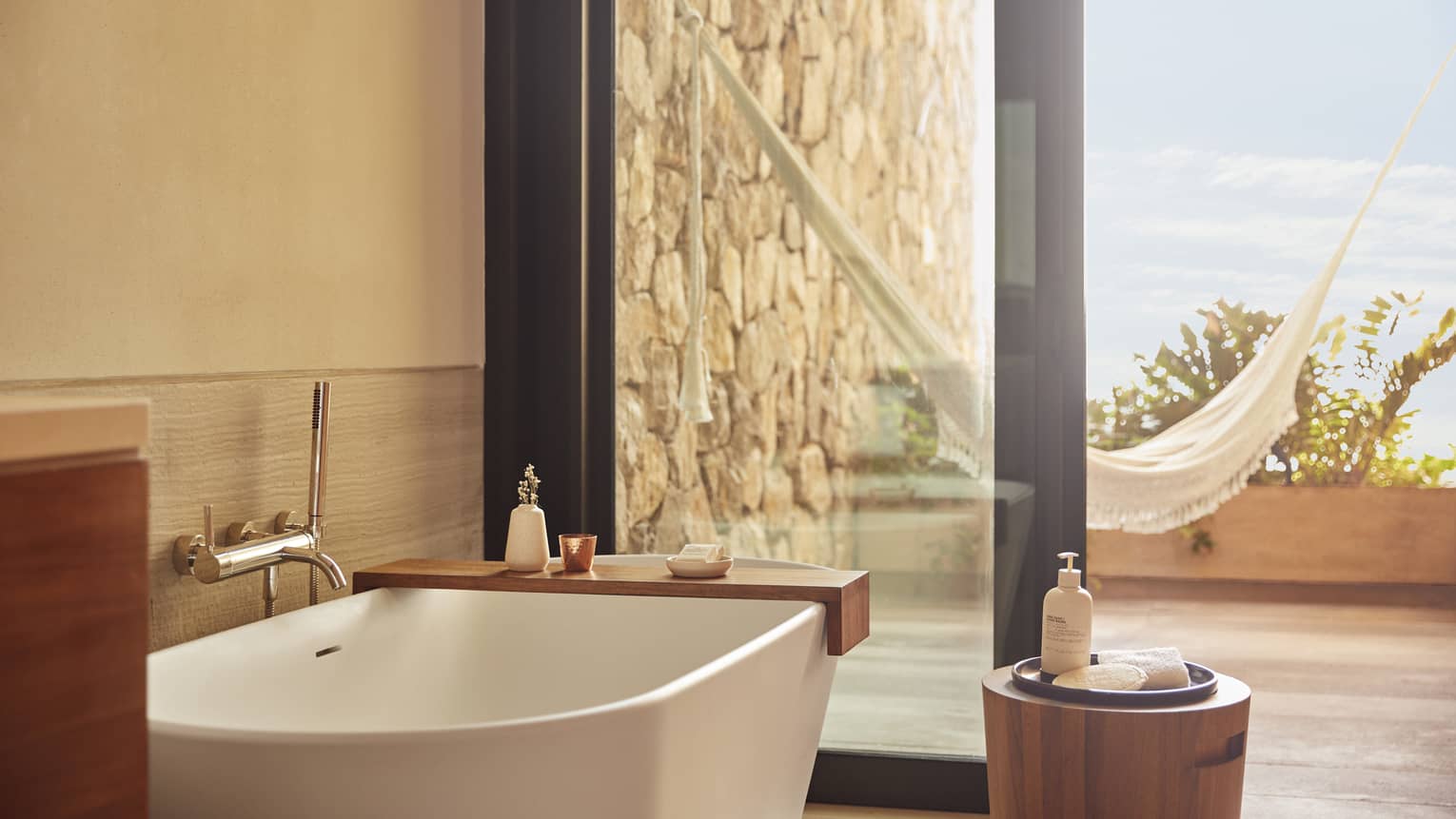 The bathroom of a beachfront room, with a large window looking outside.