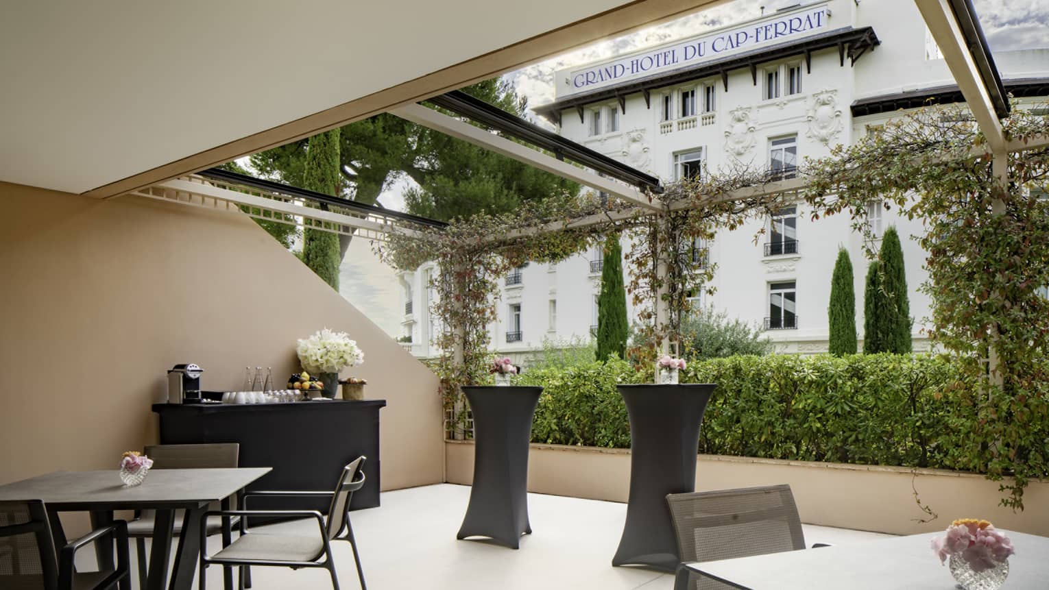 Salon Ferrat venue with square black tables, beverage service setup, open to outside