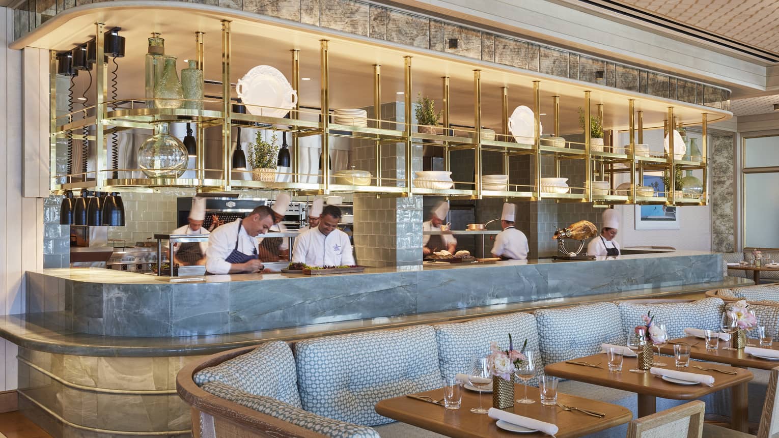 Staff members behind Flories curved blue marble bar, blue banquette seating