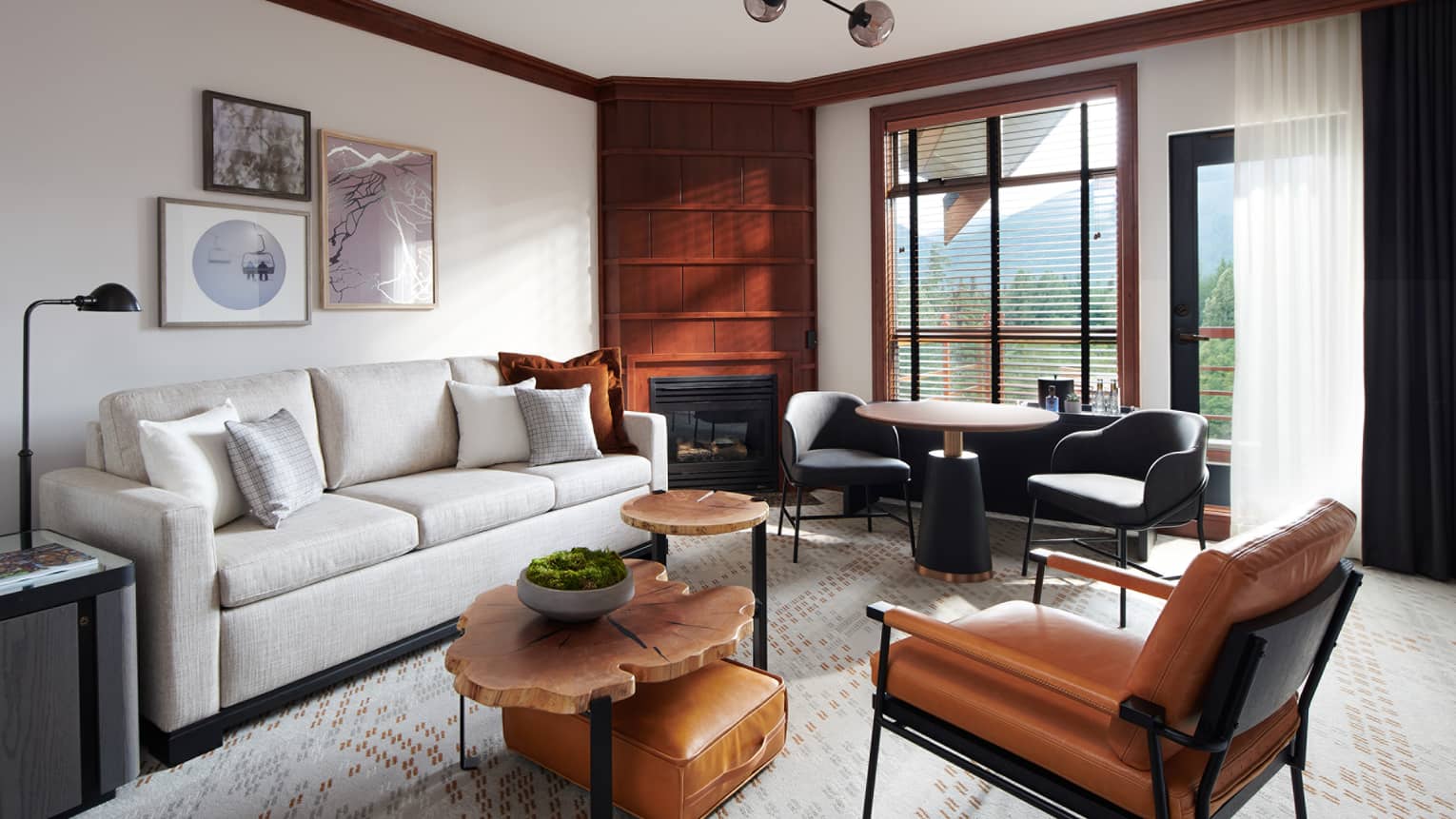 Chic and cozy Deluxe Suite at Four Seasons Whistler, showcasing a harmonious blend of contemporary and rustic elements. The living area is furnished with a sleek white sofa, tan leather chairs, a unique set of round wooden coffee tables, and a vintage-style leather suitcase used as a decorative piece. Wood-paneled walls and large windows offer views of the mountains, creating a luxurious yet inviting atmosphere. Artwork hangs above the sofa, adding a touch of elegance to the space.,Chic and cozy Deluxe Suite at Four Seasons Whistler, showcasing a harmonious blend of contemporary and rustic elements. The living area is furnished with a sleek white sofa, tan leather chairs, a unique set of round wooden coffee tables, and a vintage-style leather suitcase used as a decorative piece. Wood-paneled walls and large windows offer views of the mountains, creating a luxurious yet inviting atmosphere. Artwork hangs above the sofa, adding a touch of elegance to the space.