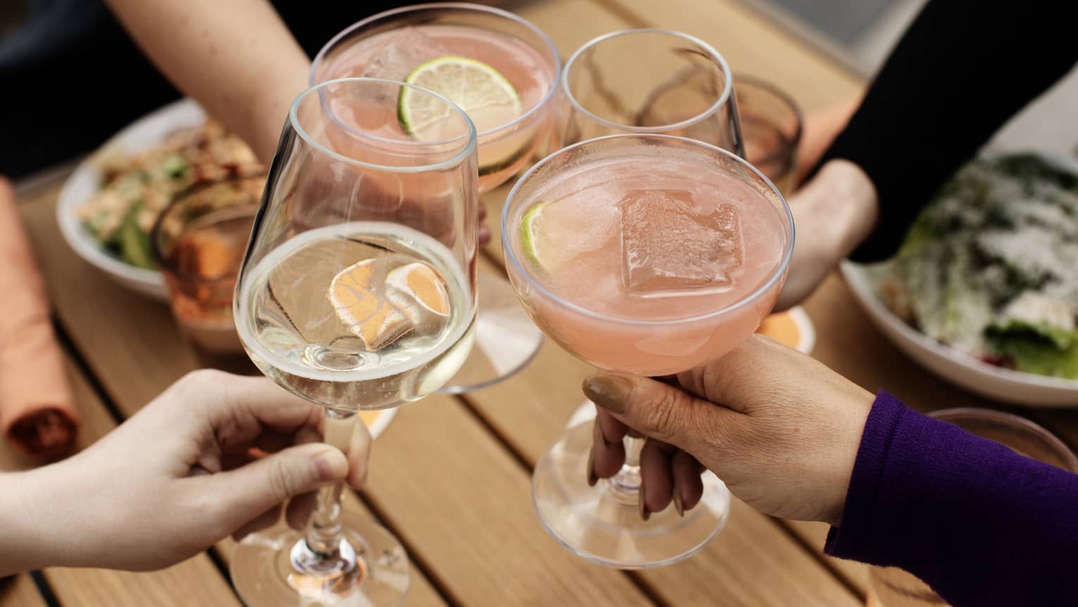 A group of people toasting with wine and cocktails.