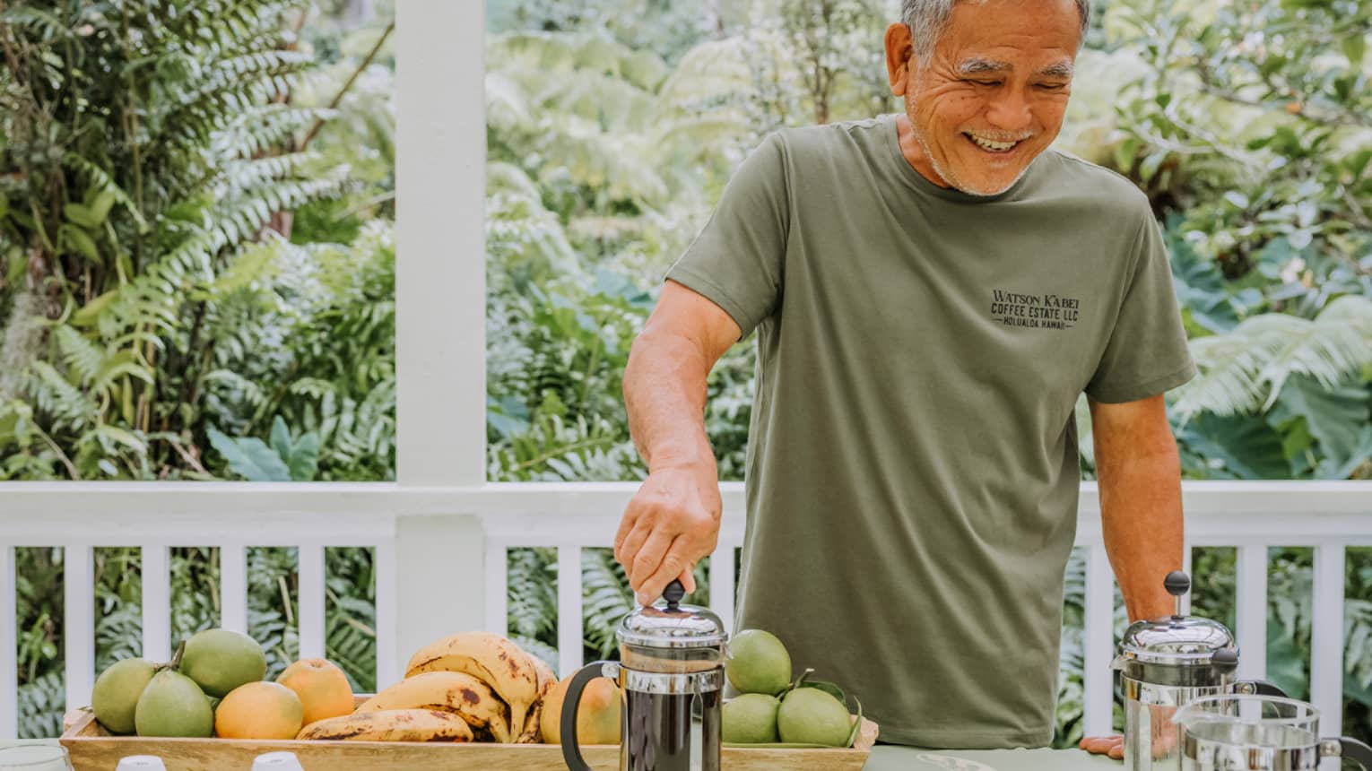 Smiling makes fresh-brewed coffee in a French press on the balcony of a house