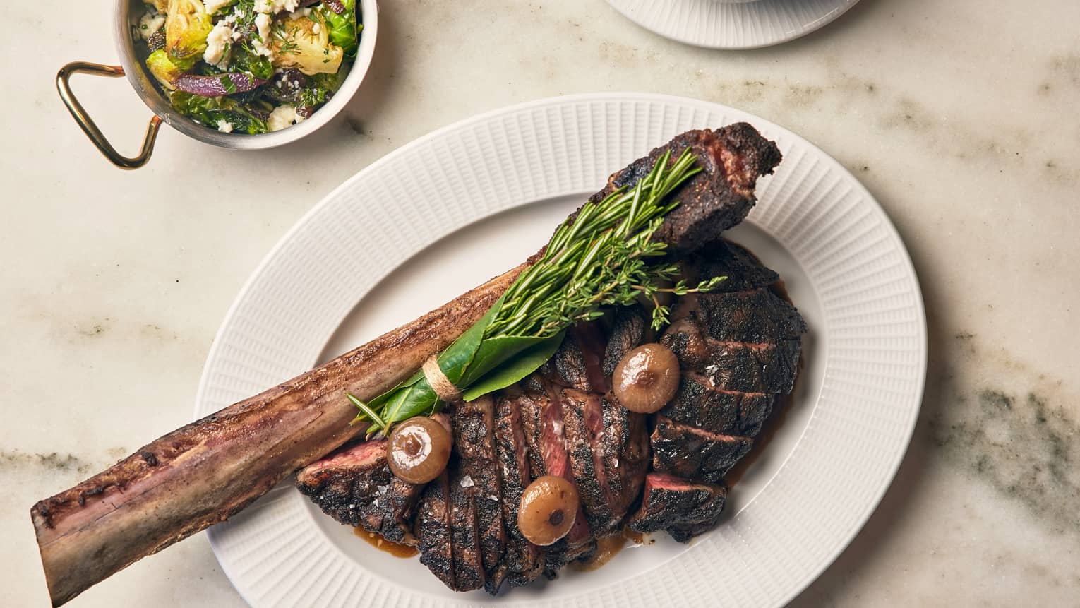  Steak with herbs on a white plate.