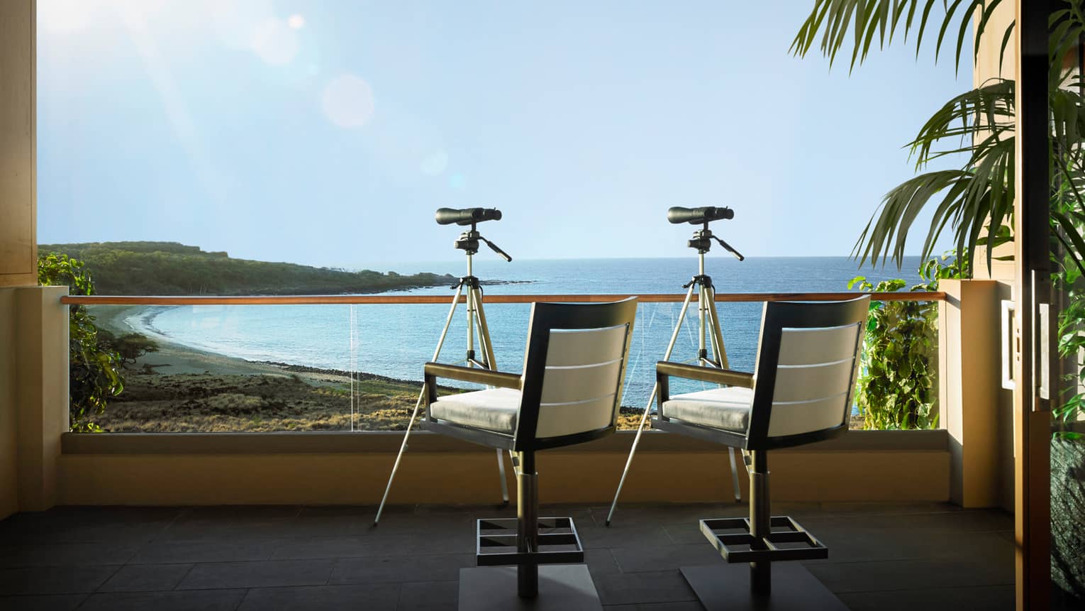 Two chairs and telescopes on a private balcony, overlooking Hawaiian beach