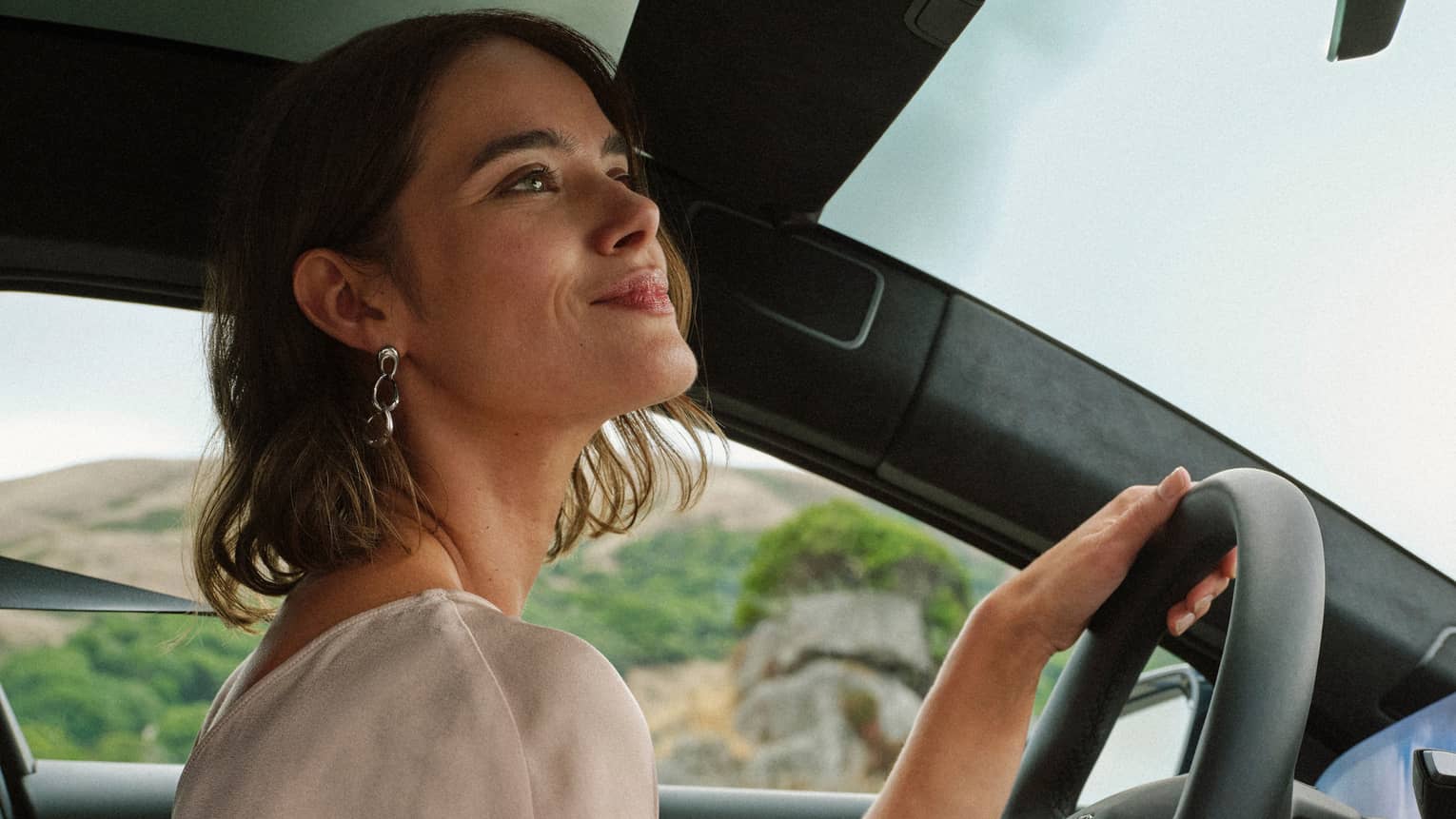 A guest looking out of the front window while driving a car