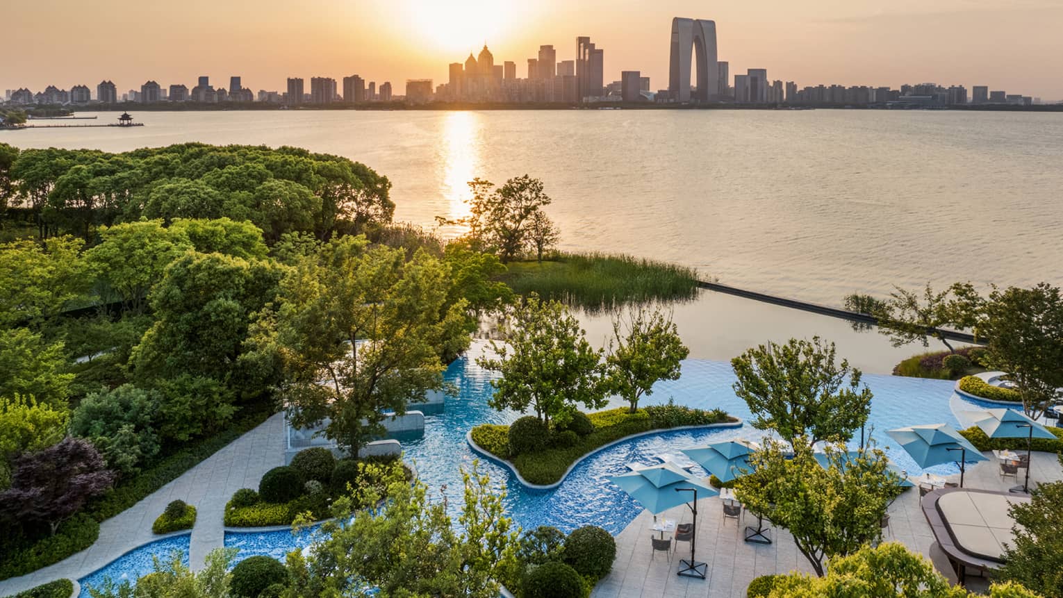 Exterior aerial shot of Four Seasons Hotel Suzhou pool grounds, with Jinji Lake and city centre in the distance
