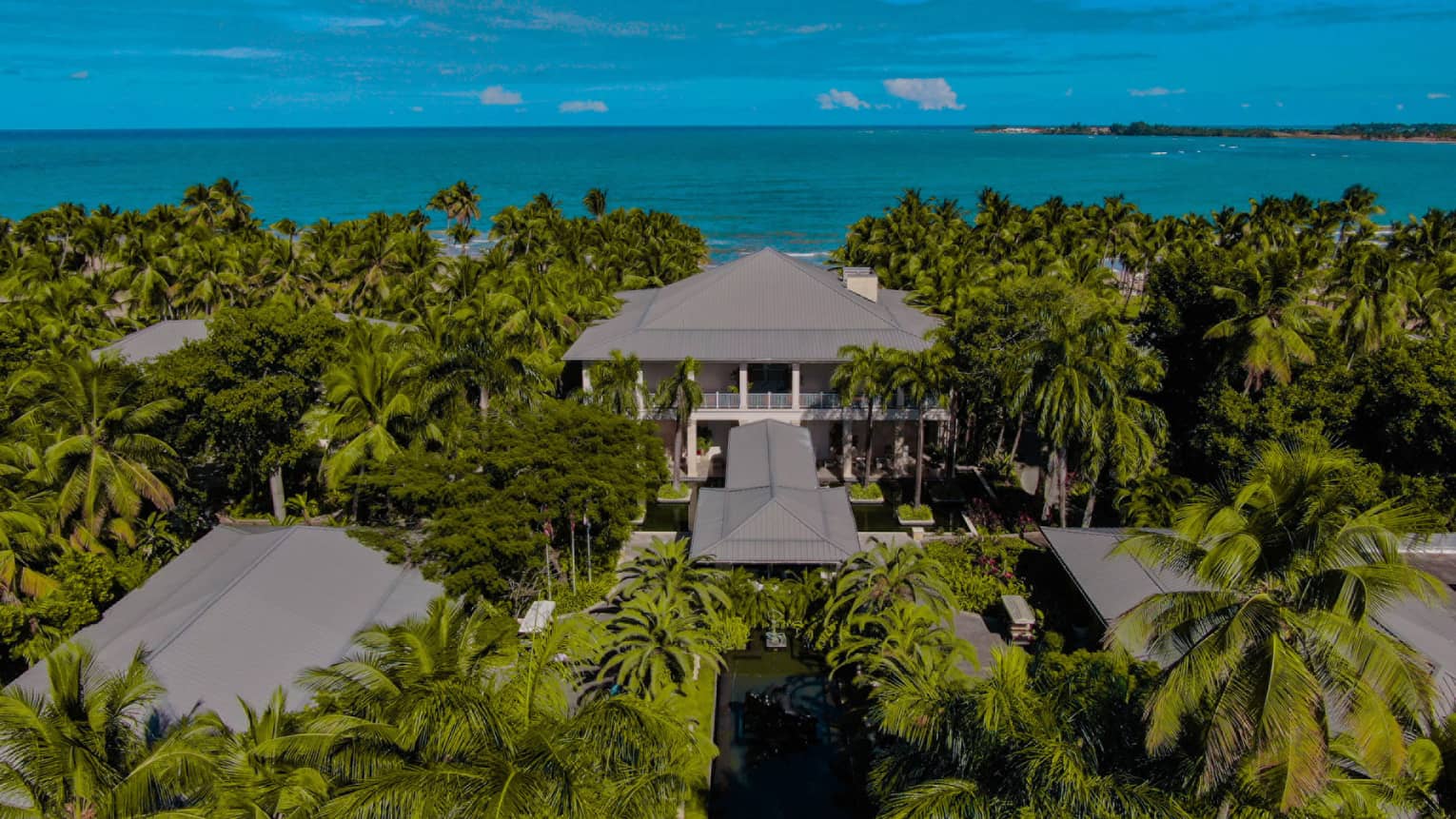 Aerial view of residence, lush jungle and ocean