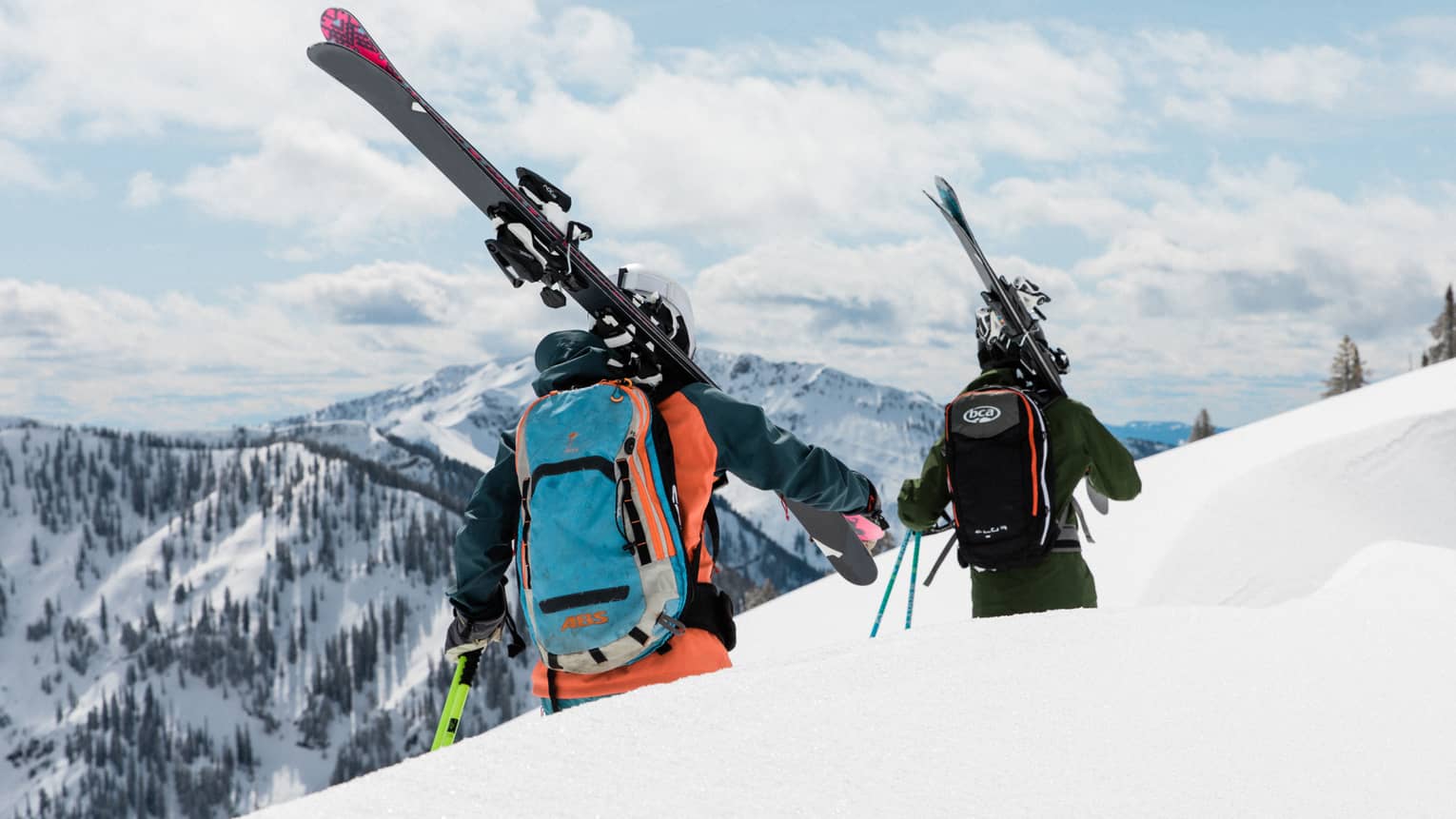 Two people in ski gear walking along a ski trail