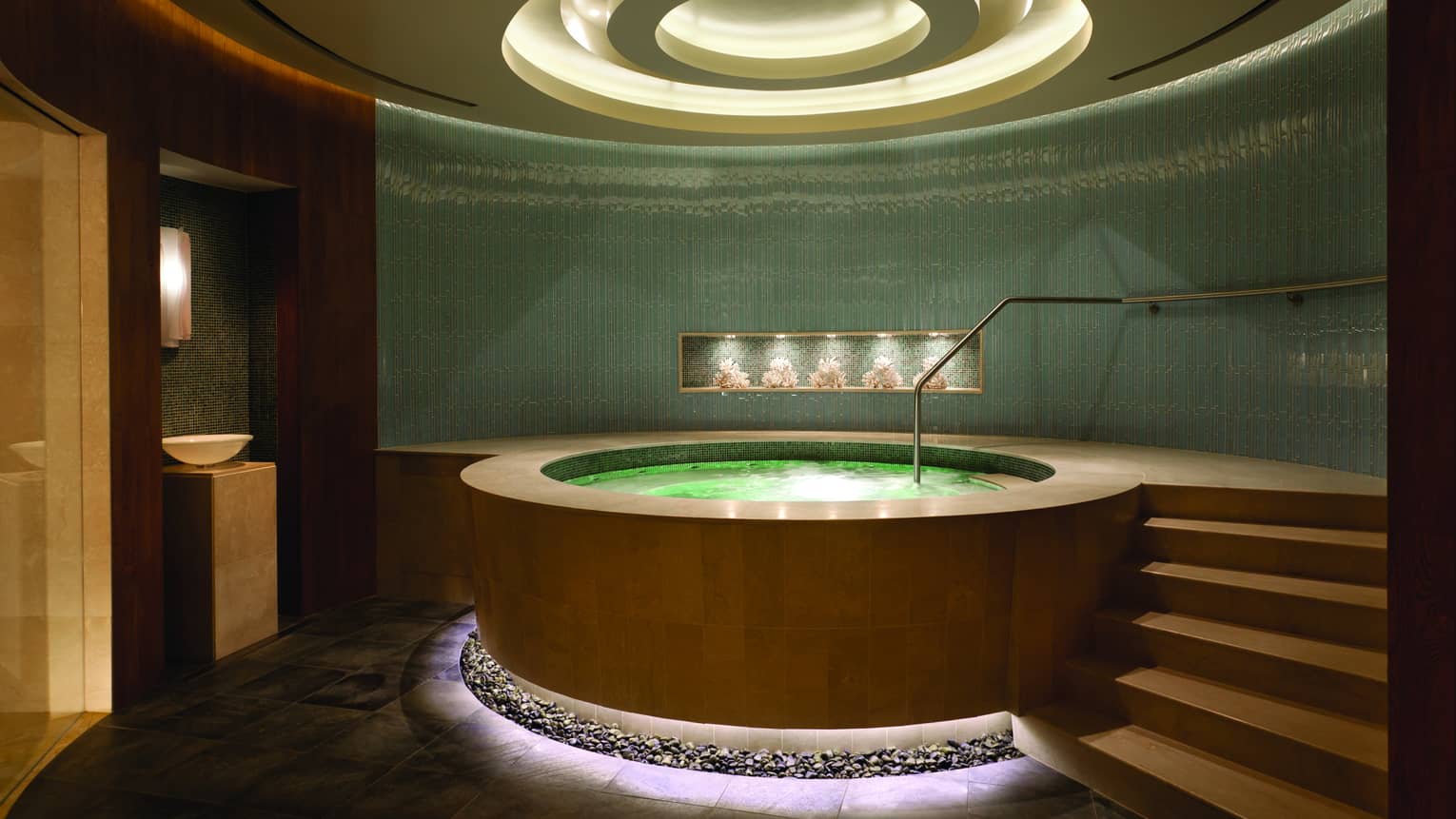 Round illuminated spa whirlpool in room with steps, recessed dome ceiling with lights 