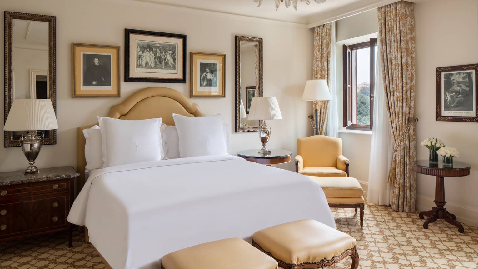 Four Seasons Room at Four Seasons Hotel Firenze, with soft-yellow furniture, framed art, lamps and tree view through window