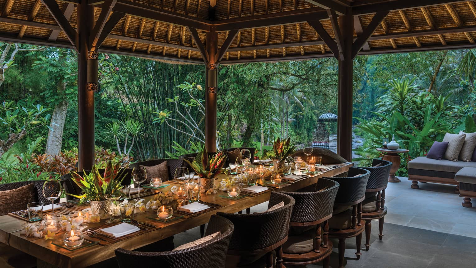 Long private dining table with candles under Royal Villa outdoor pavilion