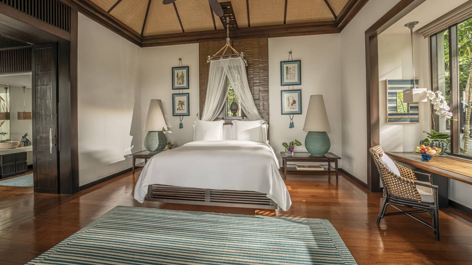 Master bedroom with teak floors, king bed with canopy net, vaulted ceiling and ceiling fan