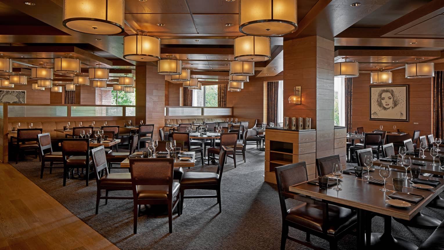A dimly lit restaurant with large wood tables.