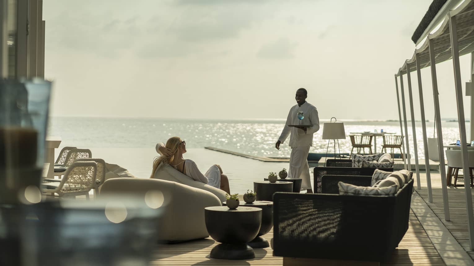 A guest receives a cocktail while relaxing outside at the Blu Beach Club