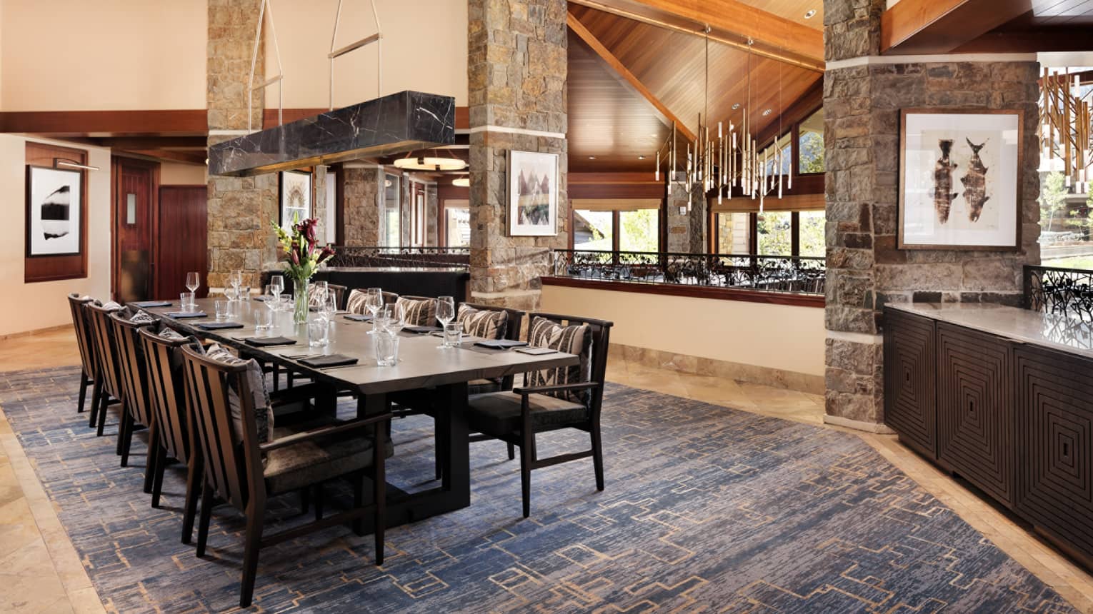 Elegant restaurant dining table with fresh-cut flowers and ten seats on the upper level of Westbank Grill
