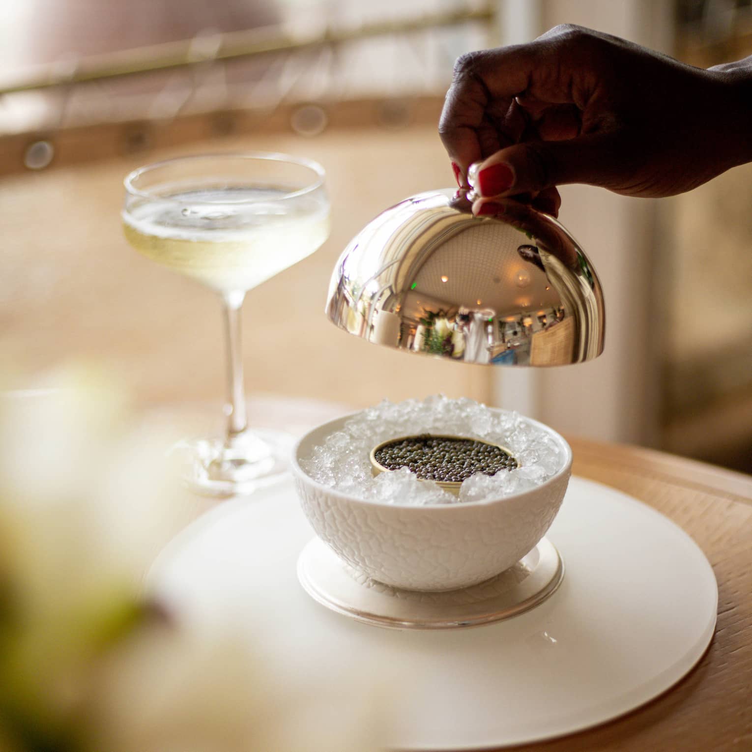 Caviar on ice next to a glass of wine.