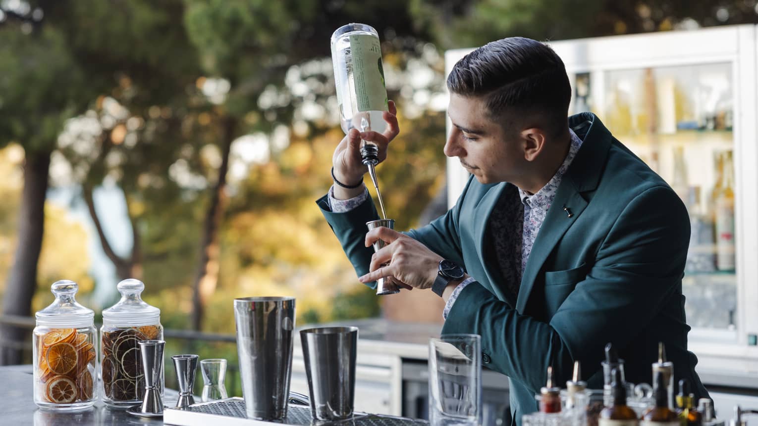 A bartender making a cocktail at an outdoor bar