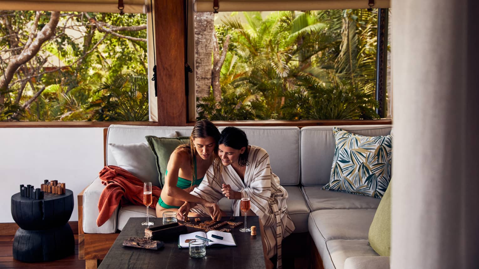 Two women drinking wine in a luxury tent.