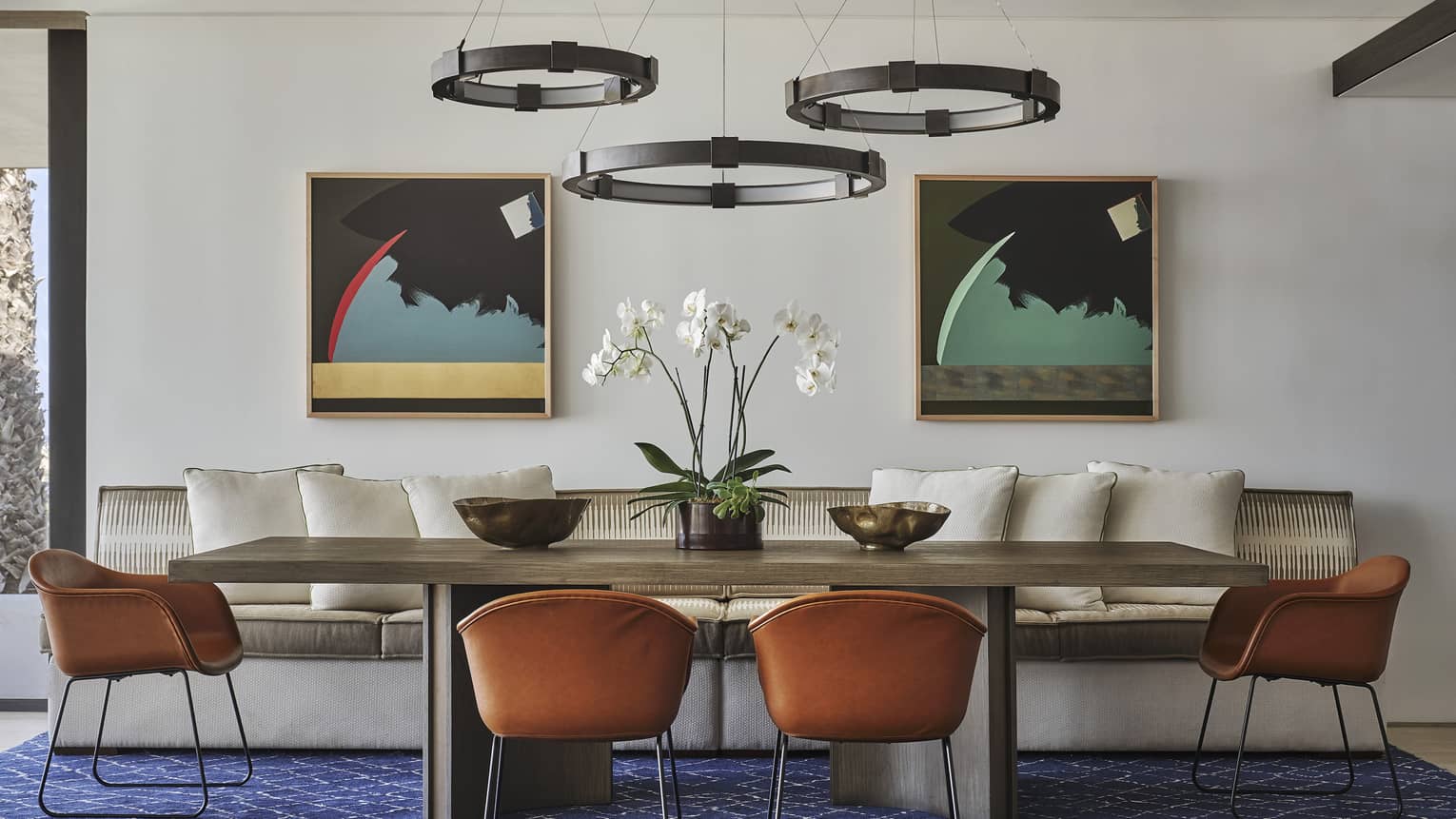 Two Bedroom Sunrise Suite dining area with rectangular dining table, blue area rug, wrought iron overhead lighting