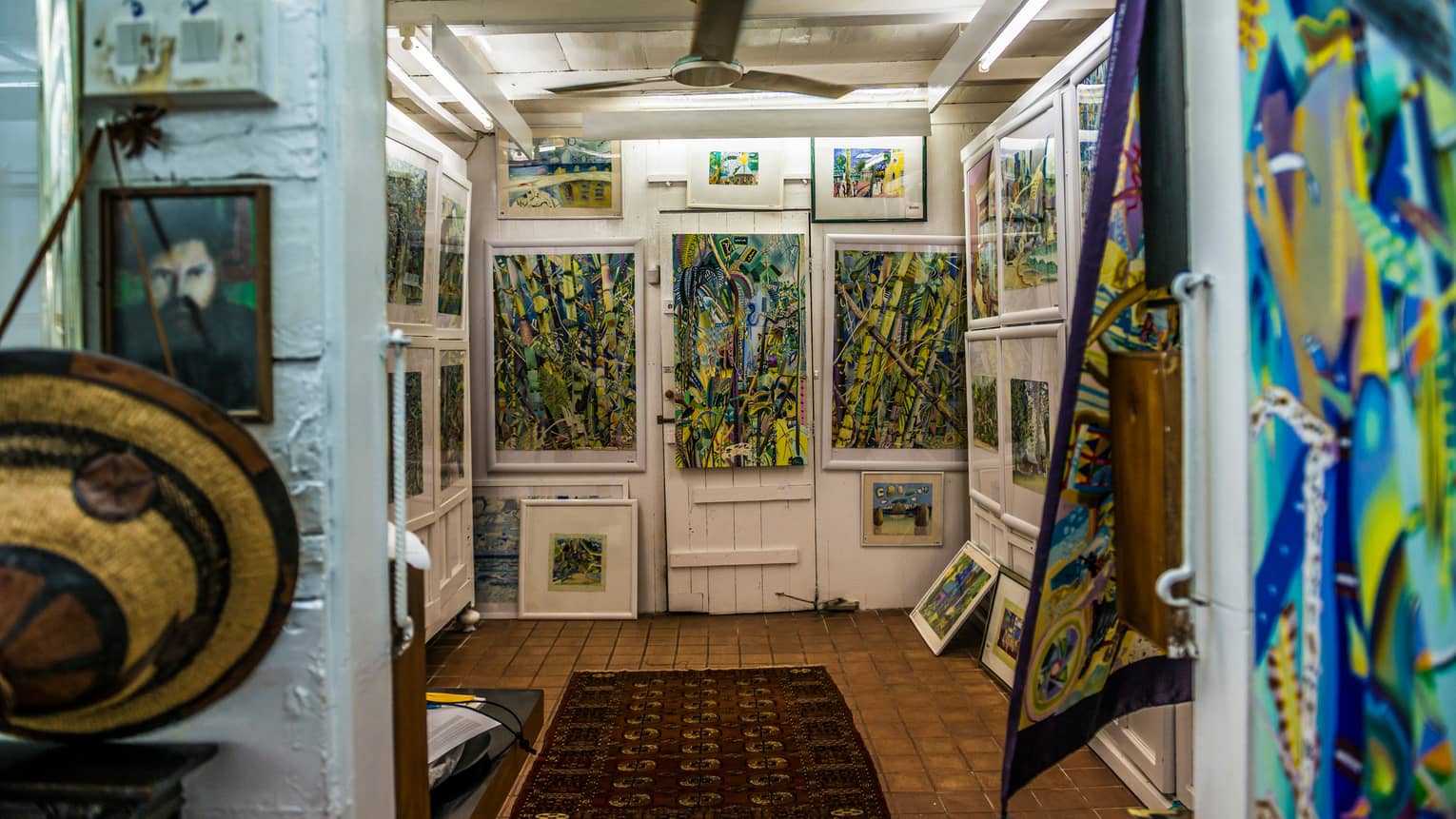 Interior of Michael Adams Gallery with colourful paintings on white walls 