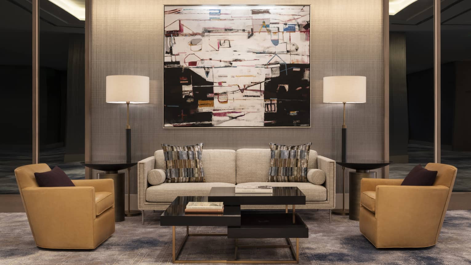 A sitting area with a small sofa, two chairs and a coffee table.