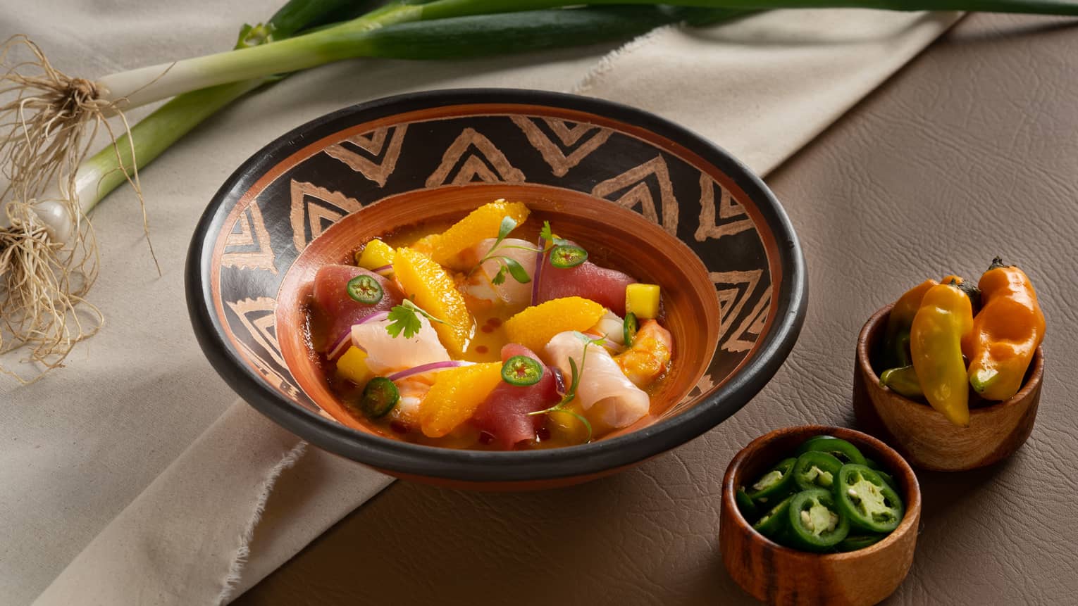Seafood Ceviche served in a red clay bowl with decorative black markings