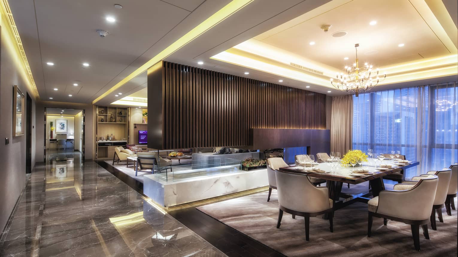 Presidential Suite large dining room, modern wood fireplace separating living room, marble floors