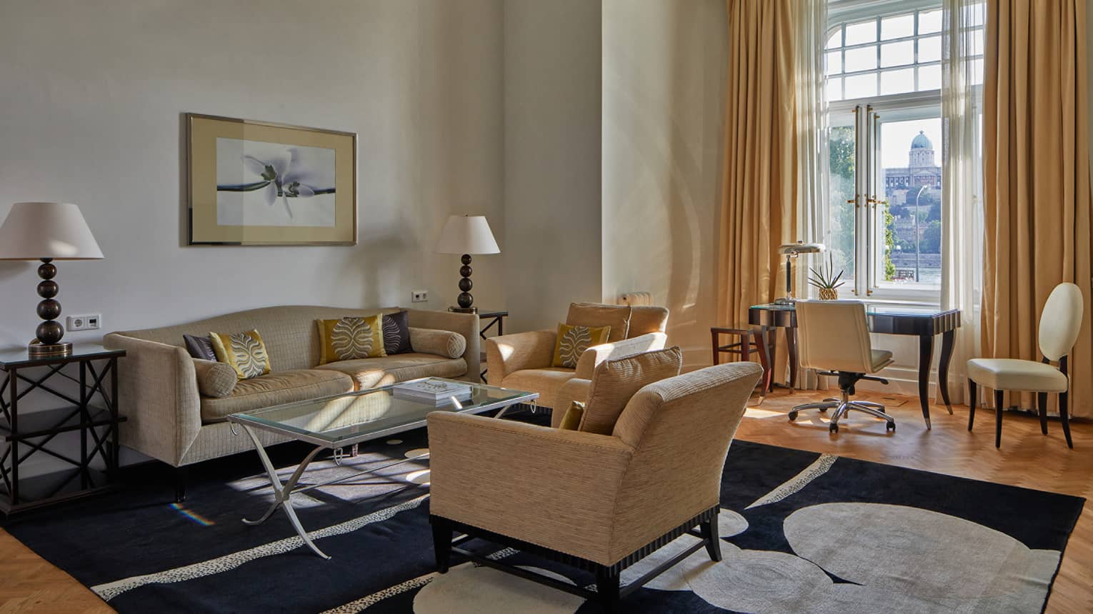 A sitting area with coffee table, sofa, chairs and desk with chair.