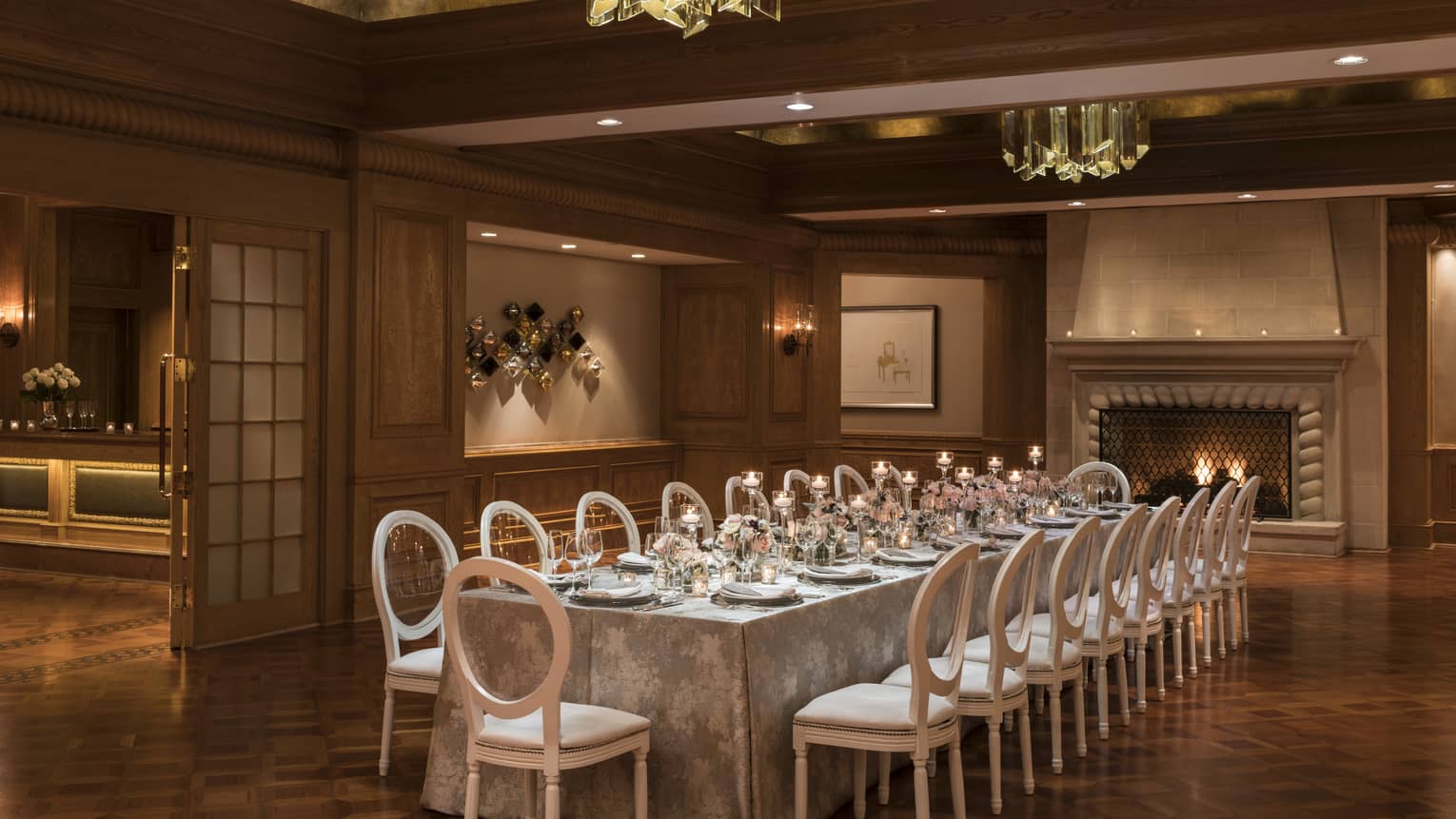 Savannah Hall banquet room with long private dining table, candles under modern crystal lights