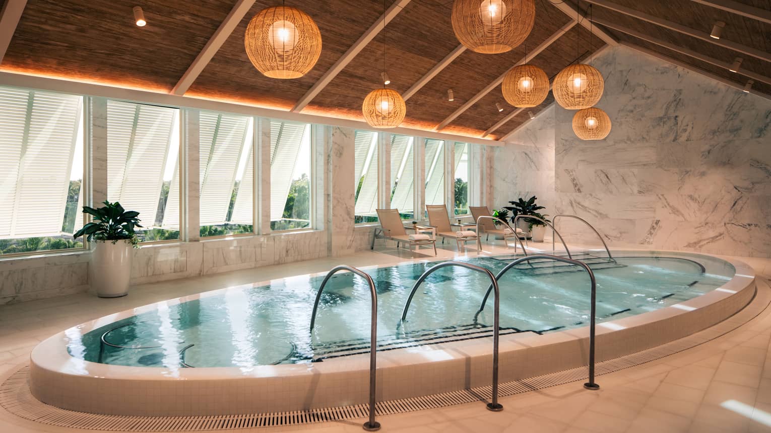 Large oblong whirlpool set beneath a tall peaked ceiling with rattan lanterns hanging in the centre