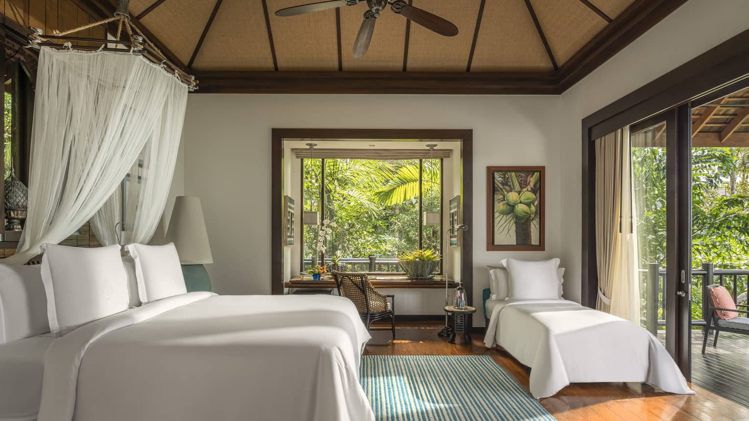 Bedroom in tropical villa, with king bed, net canopy and extra twin bed