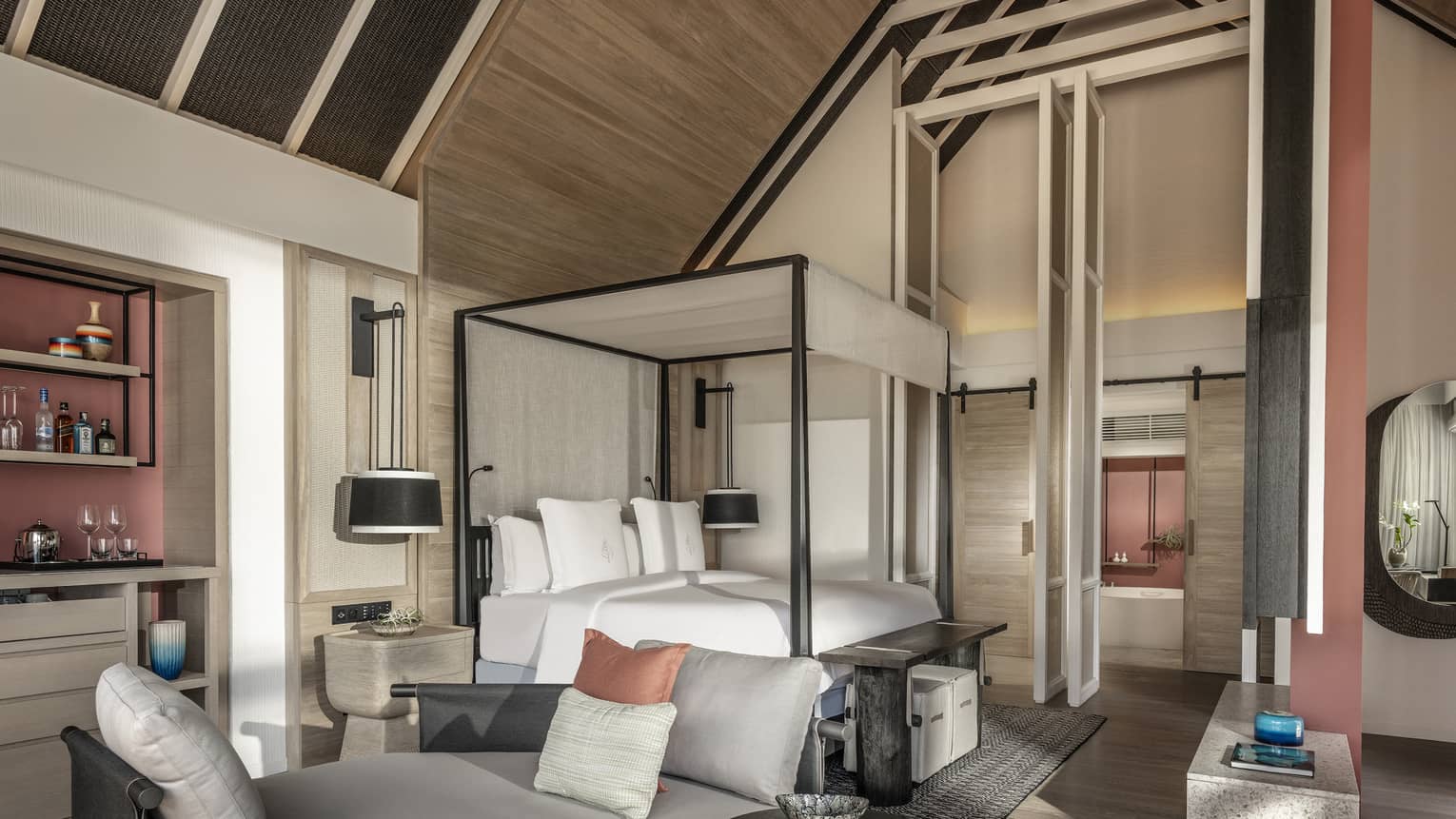 Master bedroom with vaulted beamed ceiling, canopy bed and lounge seating
