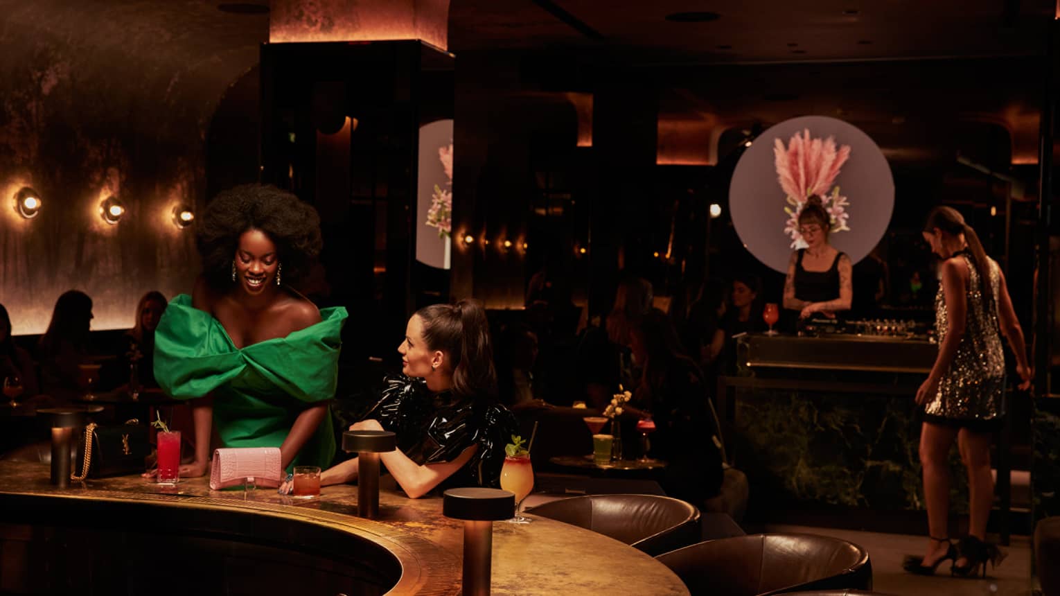 Two women in dresses at a bar.