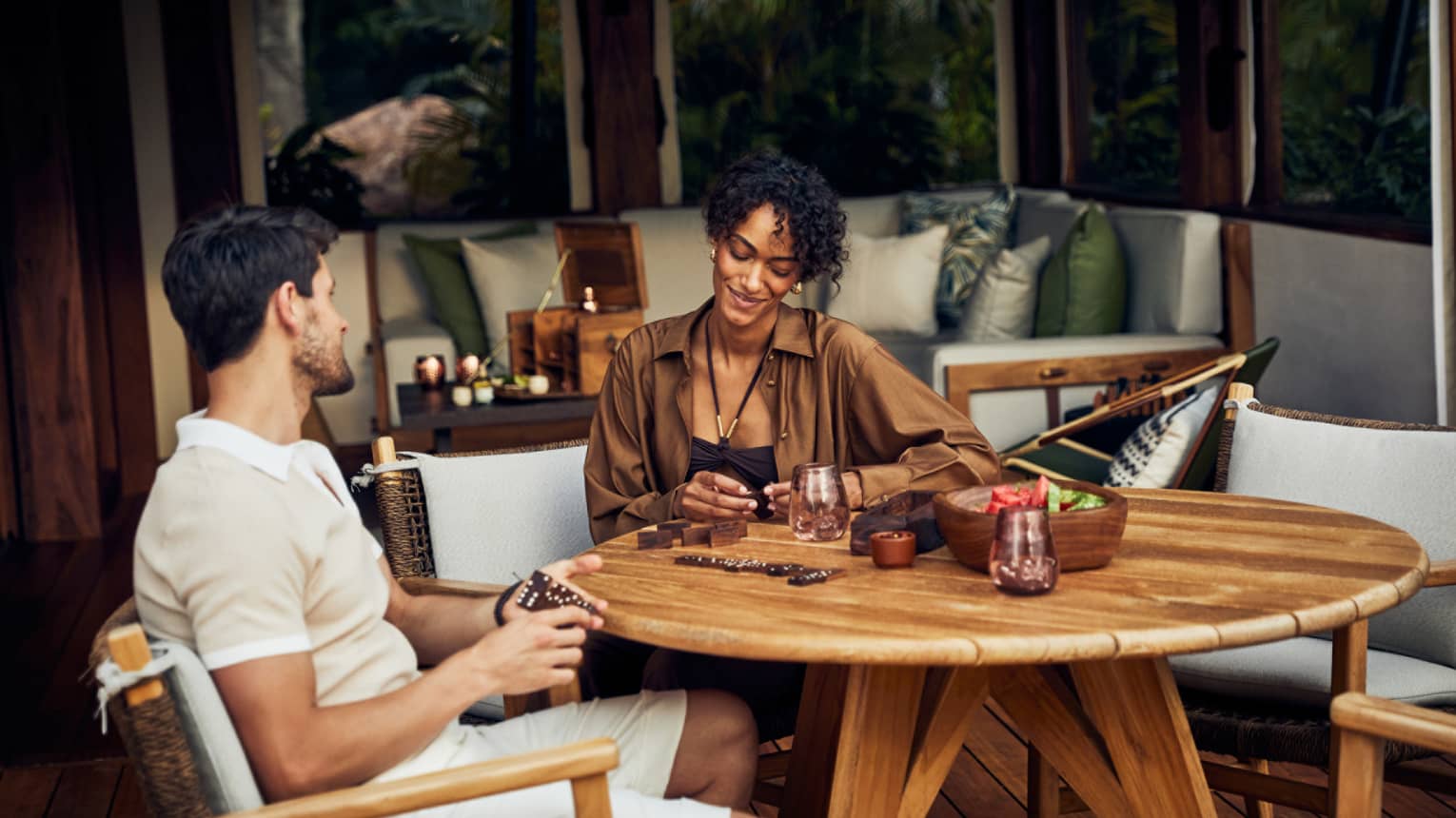 A man and woman sitting at a round table in a luxury tent.