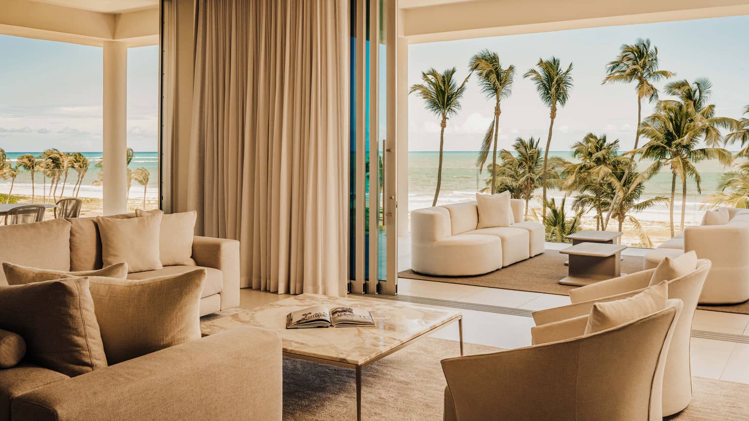 Luxury private residence with a living room opening to an outdoor lounge with ocean view
