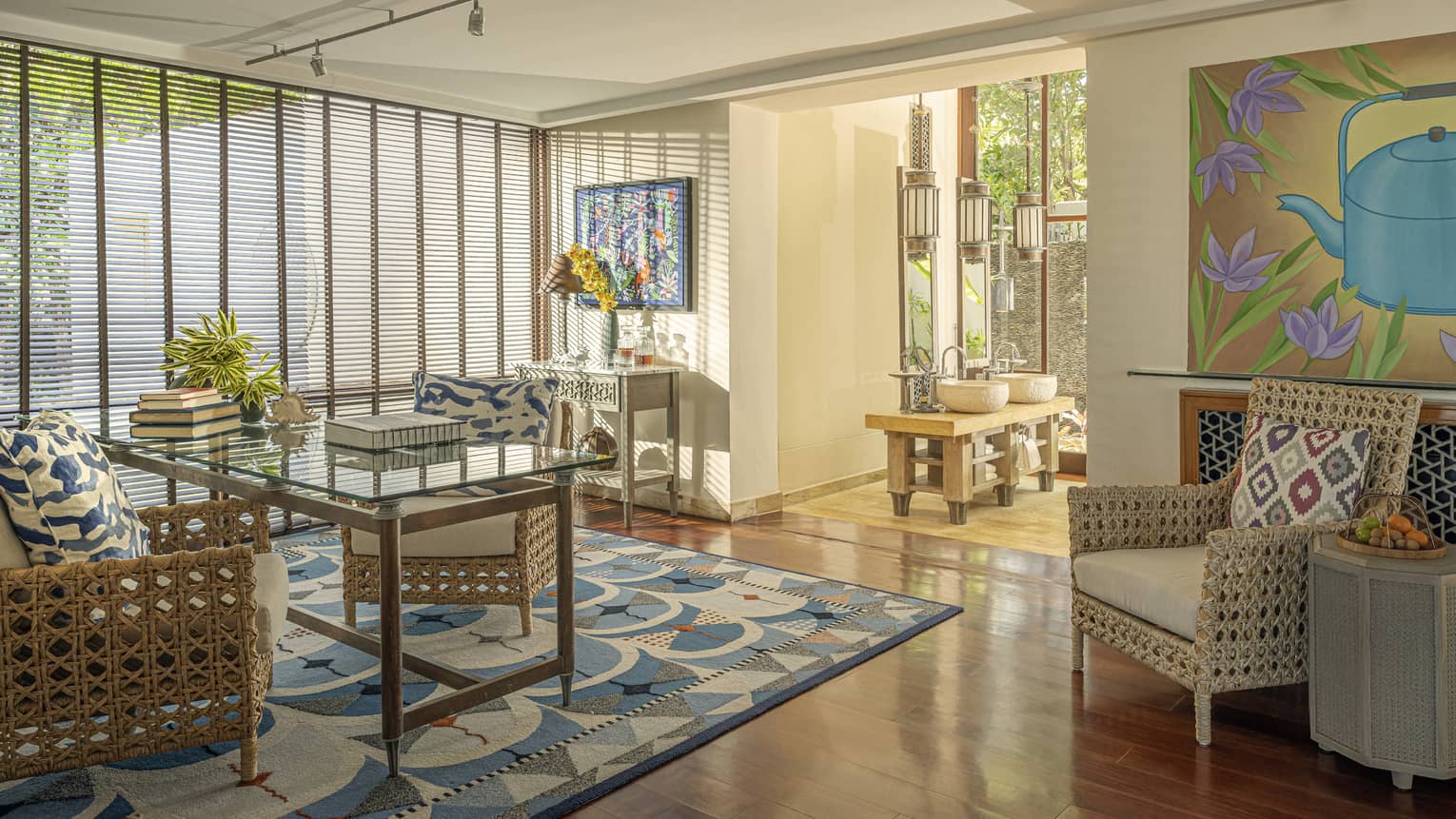 Office with glass desk, two rattan chairs, and an arm chair