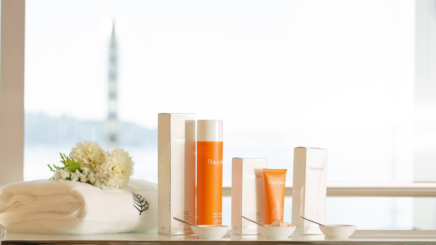 A selection of spa products in orange packaging near a window.