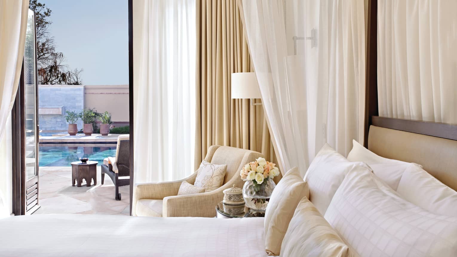 Four-Bedroom Royal Villa with Private Pool, bed with white curtains and armchair beside open balcony door to patio