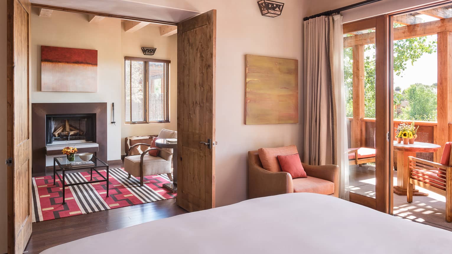 Sunset, Summit Suite bed, chair, open wood doors to seating area, sunny balcony