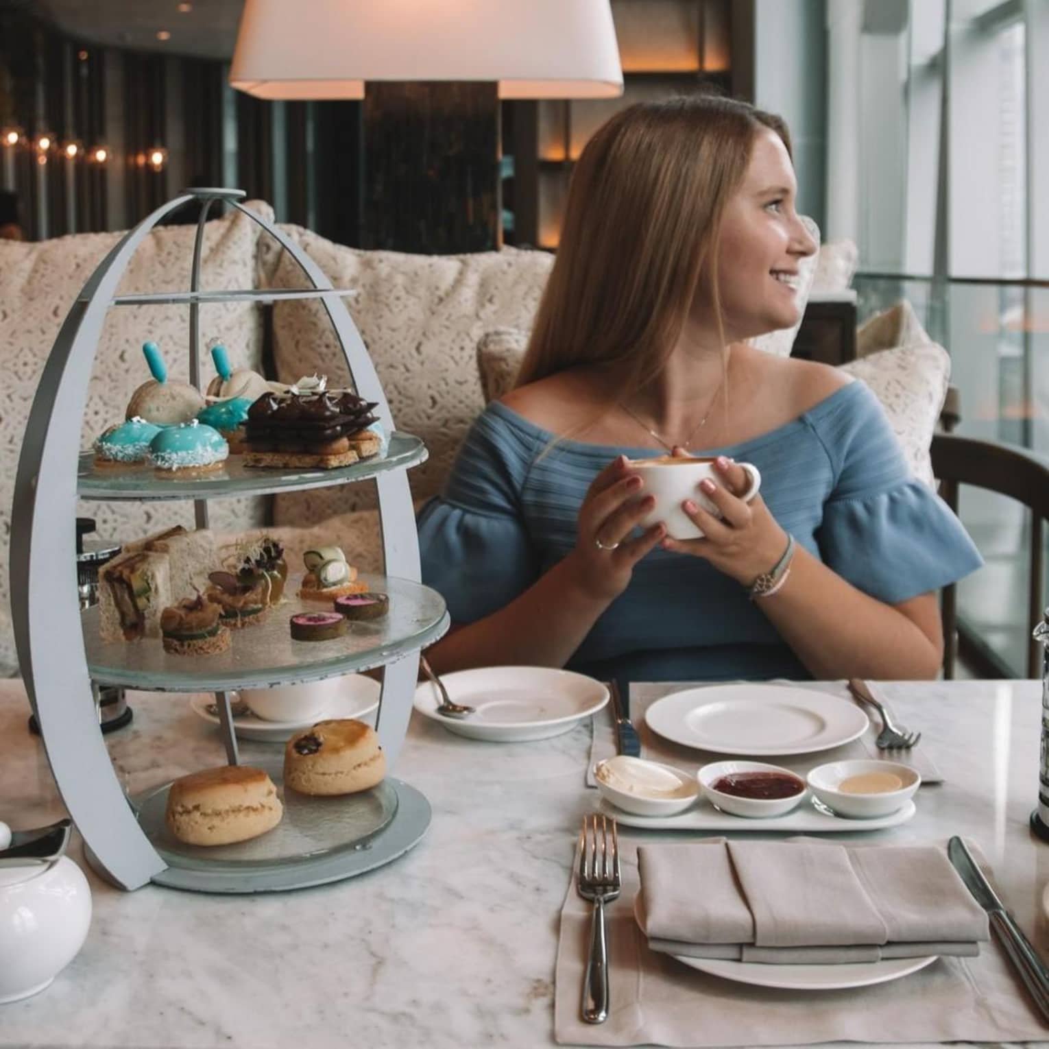 A guest enjoys afternoon tea in the lounge