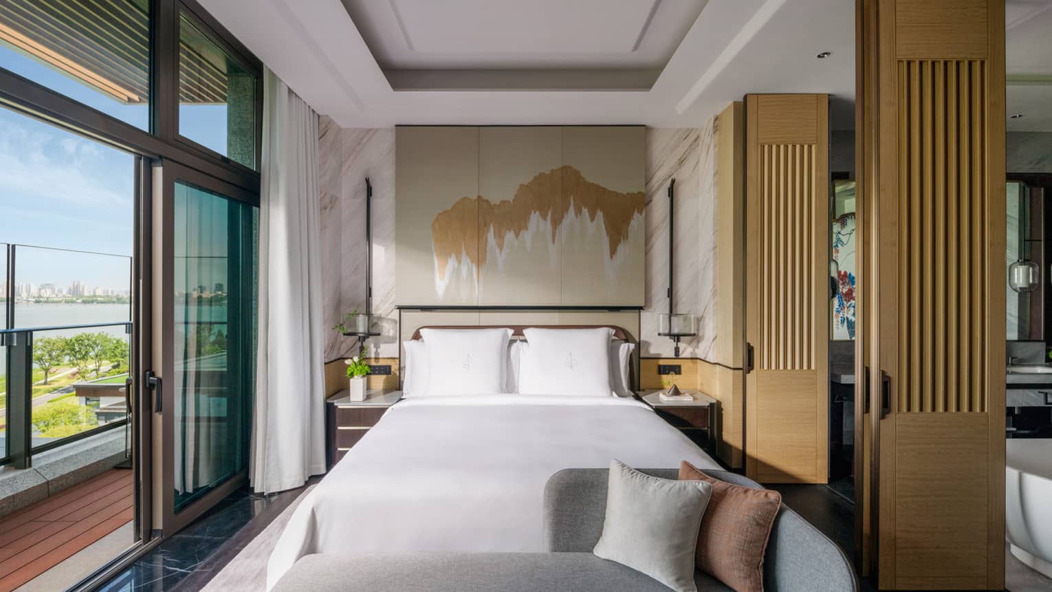 Luxury hotel bedroom with king bed, chaise and walk-out balcony in Penthouse Suite at Four Seasons Hotel Suzhou