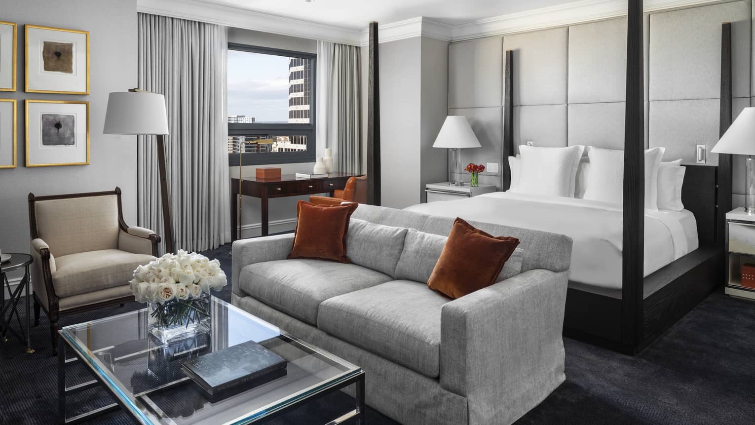 Presidential Suite poster bed against white padded wall, behind seating area 
