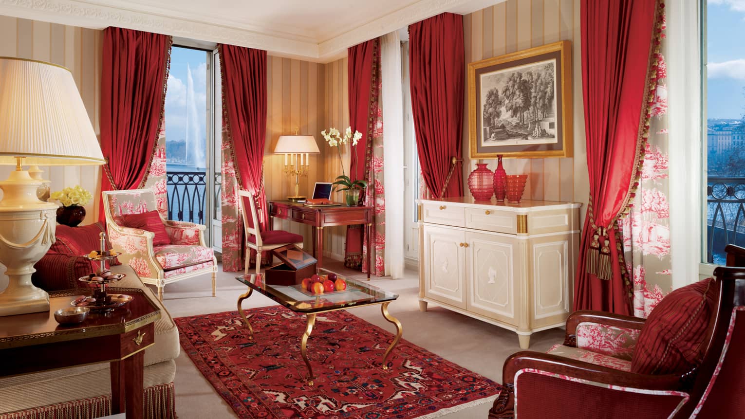 Suite Mont Blanc with dark red curtains, accent chair and rug, glass coffee table, French balcony at dusk