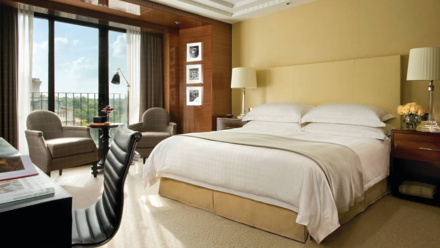 Deluxe Room bed, nightstand with flowers, modern desk, armchairs under wood panelling