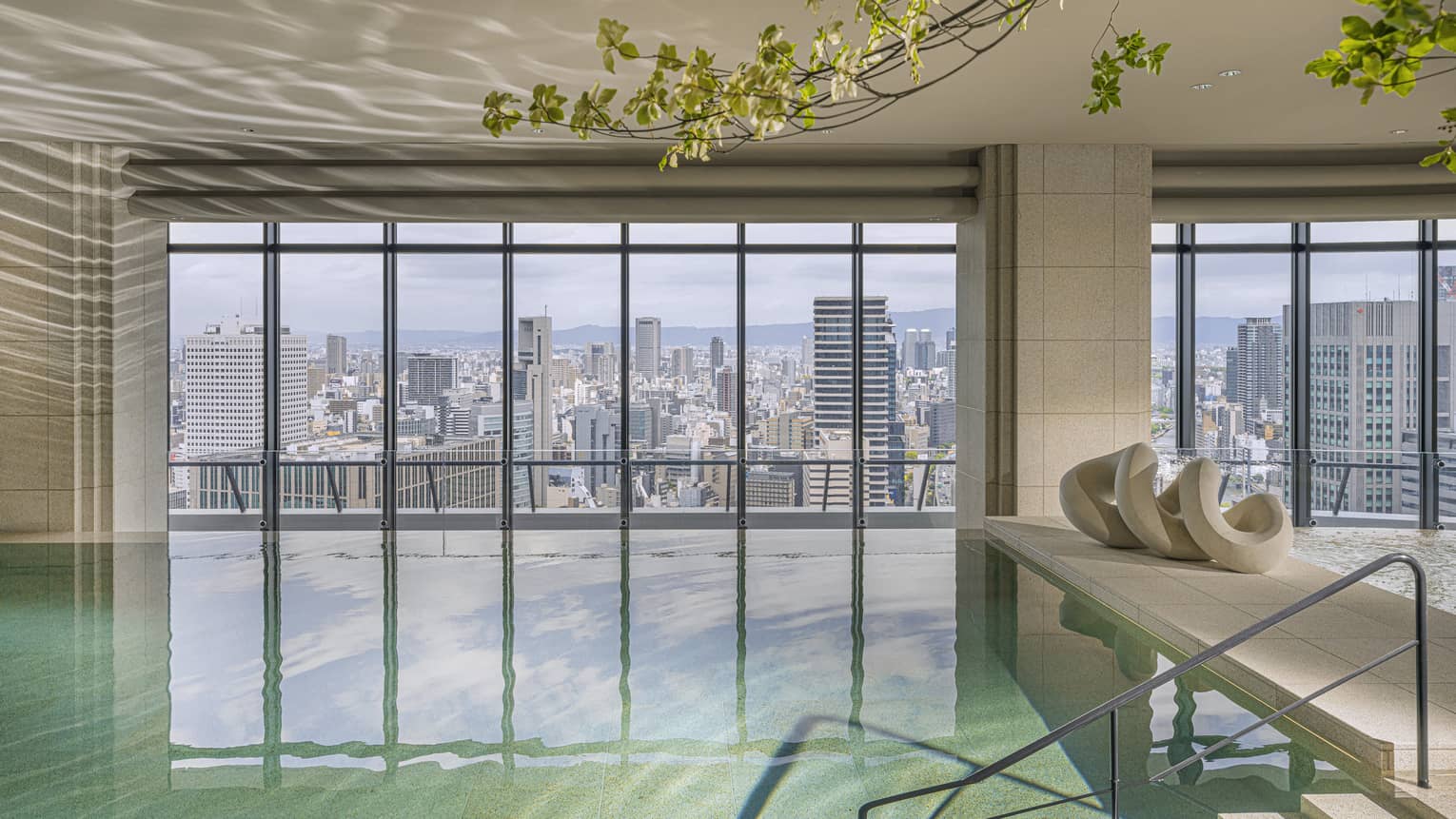 Indoor pool at Four Seasons Hotel Osaka, with wall of windows looking out to Osaka city