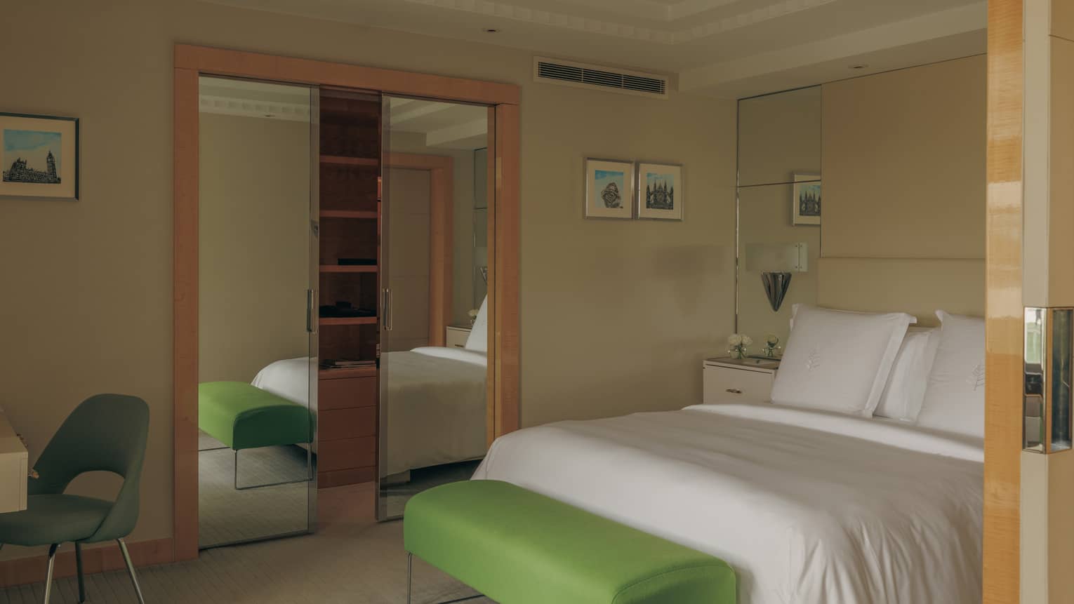 Bedroom with king bed and green bench at the foot of the bed